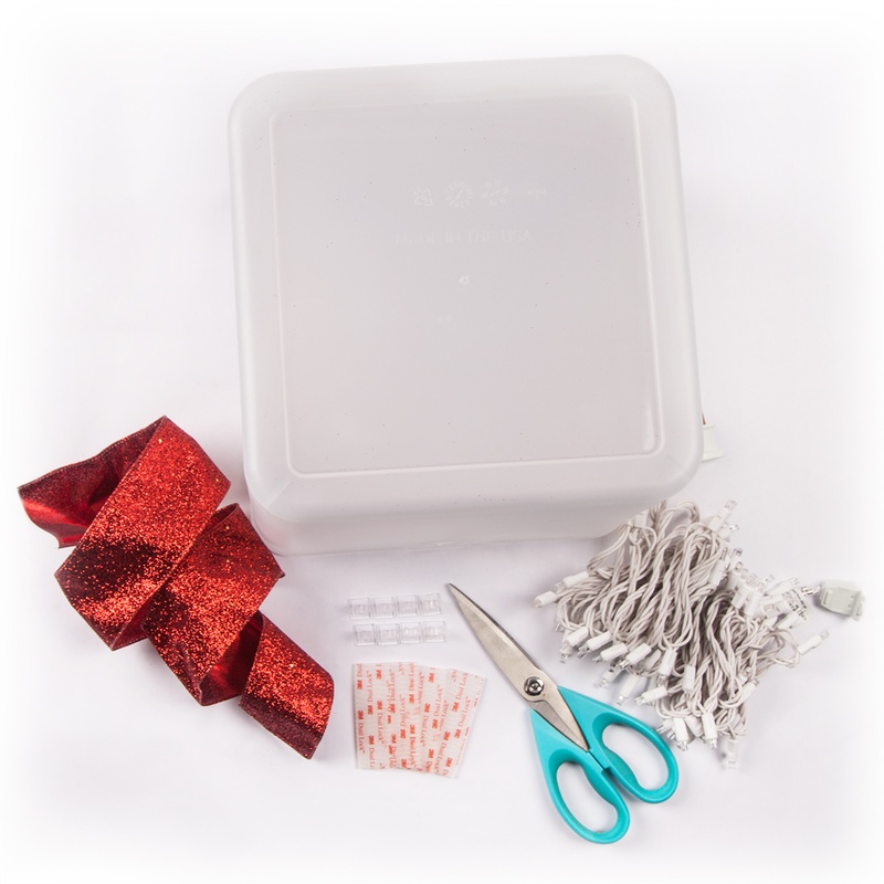 Create a DIY lighted gift box decoration for Christmas using a plastic container, ribbon and string lights!